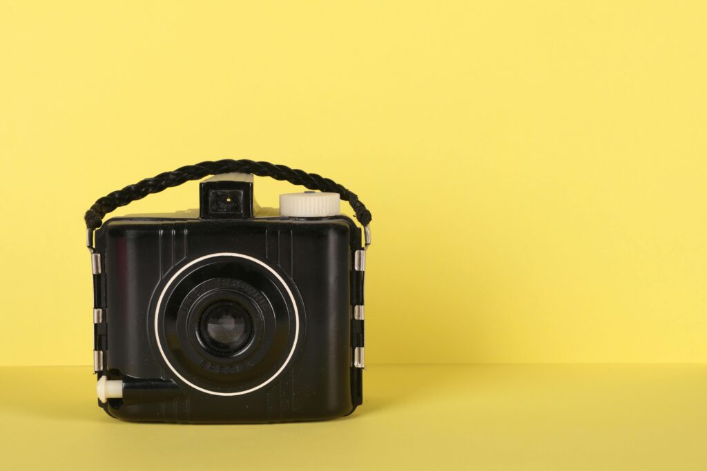 pexels-photo-1878399-1878399 Classic vintage camera against a bright yellow backdrop, showcasing timeless design.