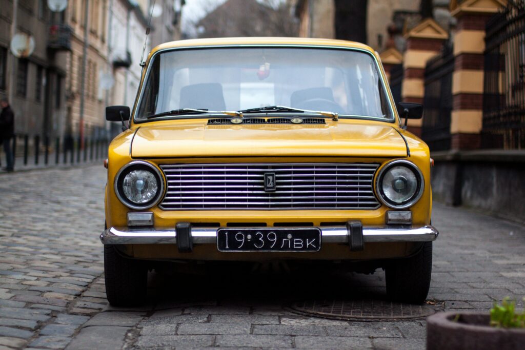 pexels-photo-253096-253096 Front view of a vintage yellow car parked on a cobblestone street in Lviv, Ukraine.