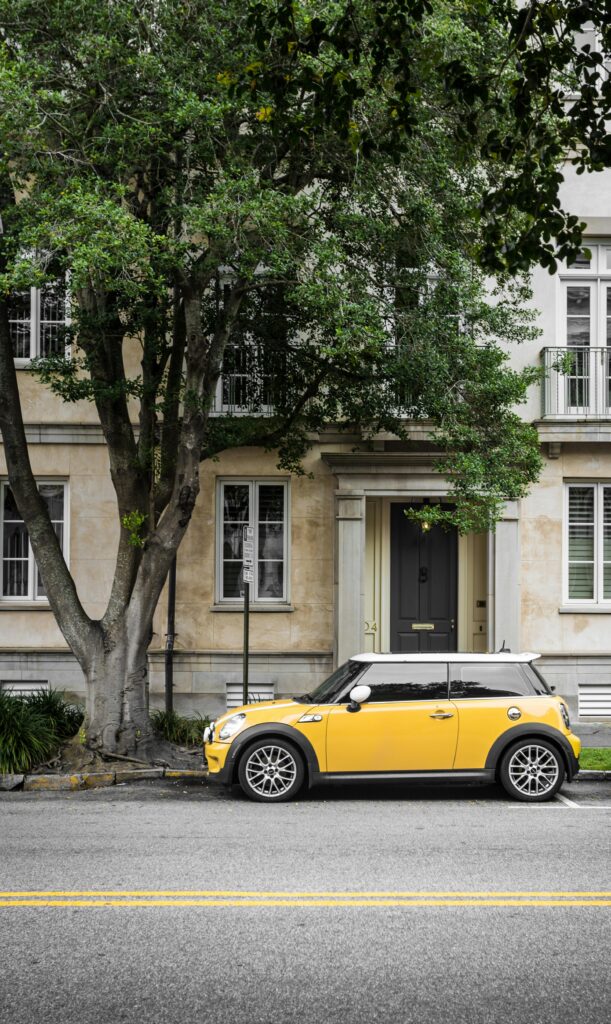 pexels-photo-457418-457418 A vibrant yellow Mini Cooper parked on a scenic street in Charleston, SC.